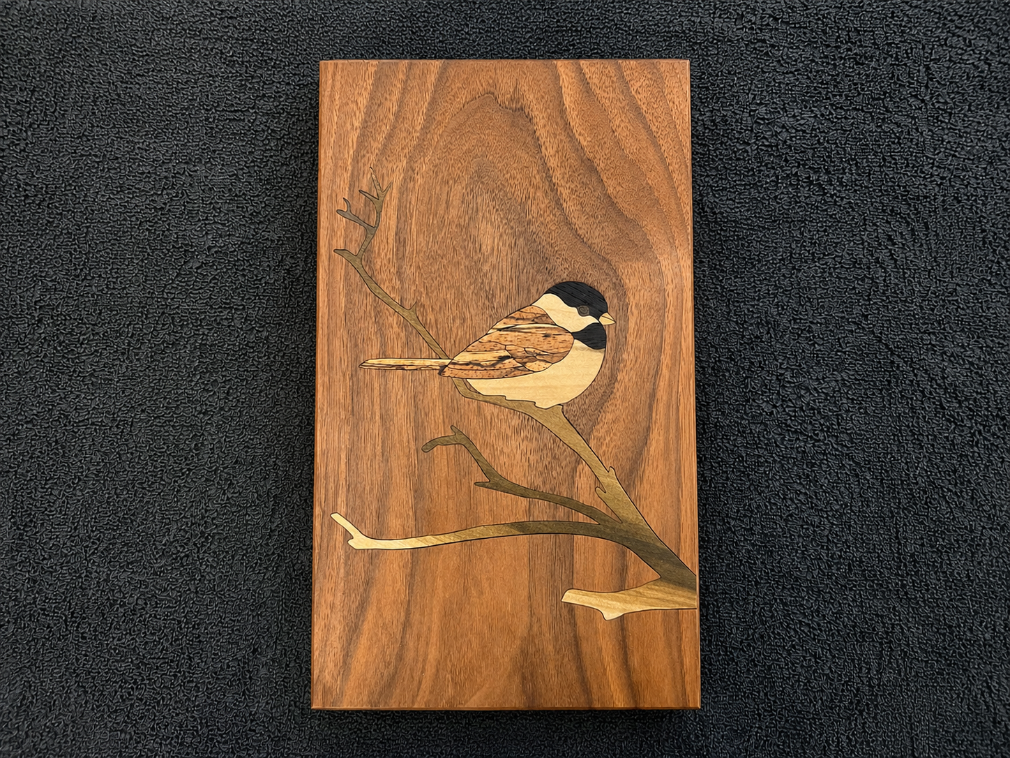 Finished chickadee wood inlay with bird perched on branches