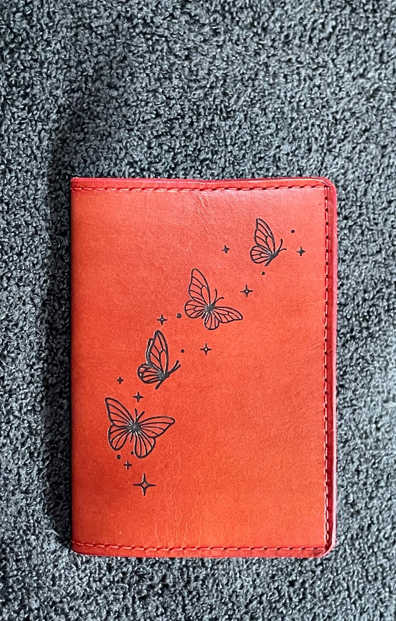 Small red leather notebook engraved with butterflies