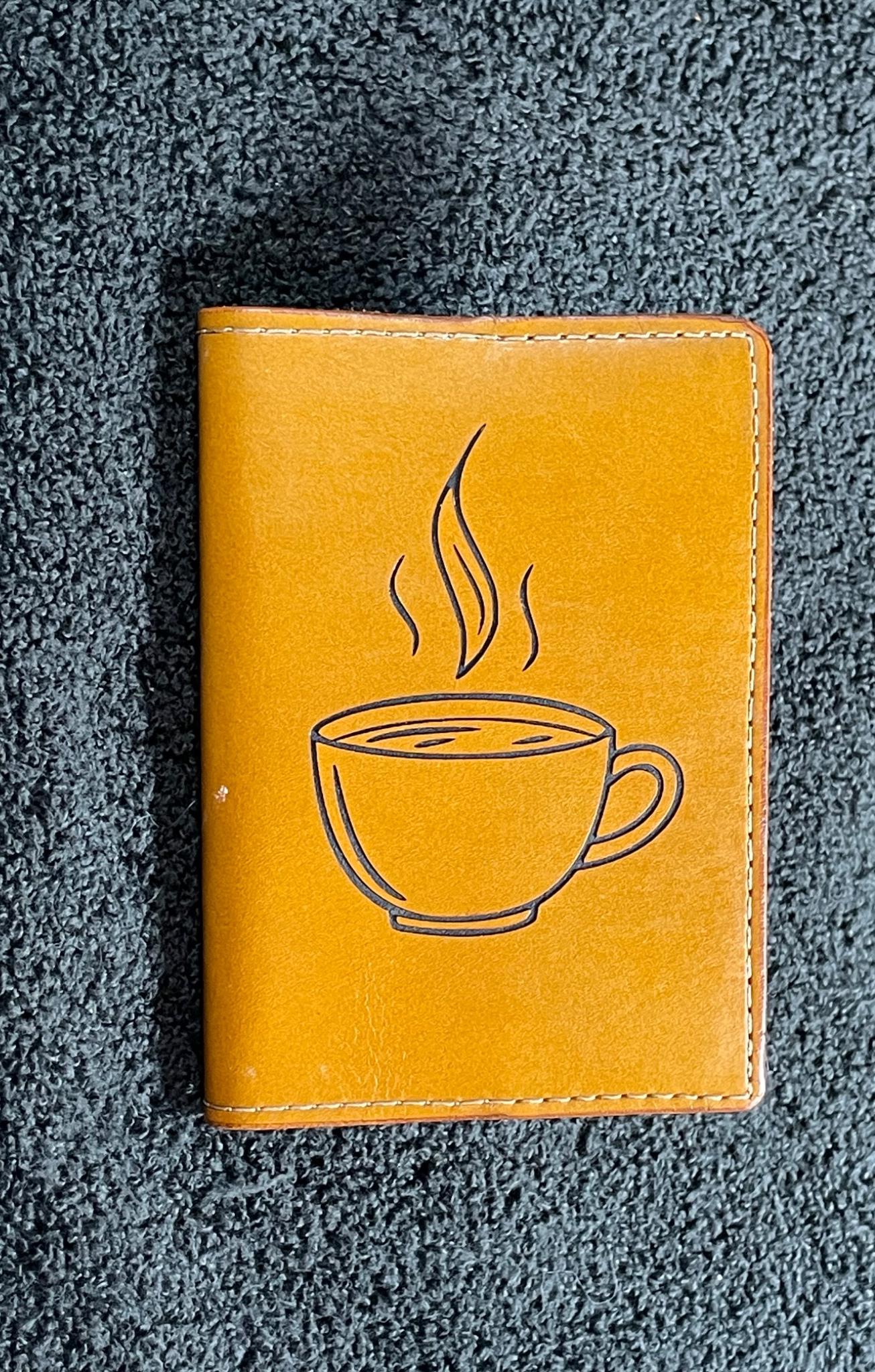 Small tan leather notebook engraved with a steaming coffee cup