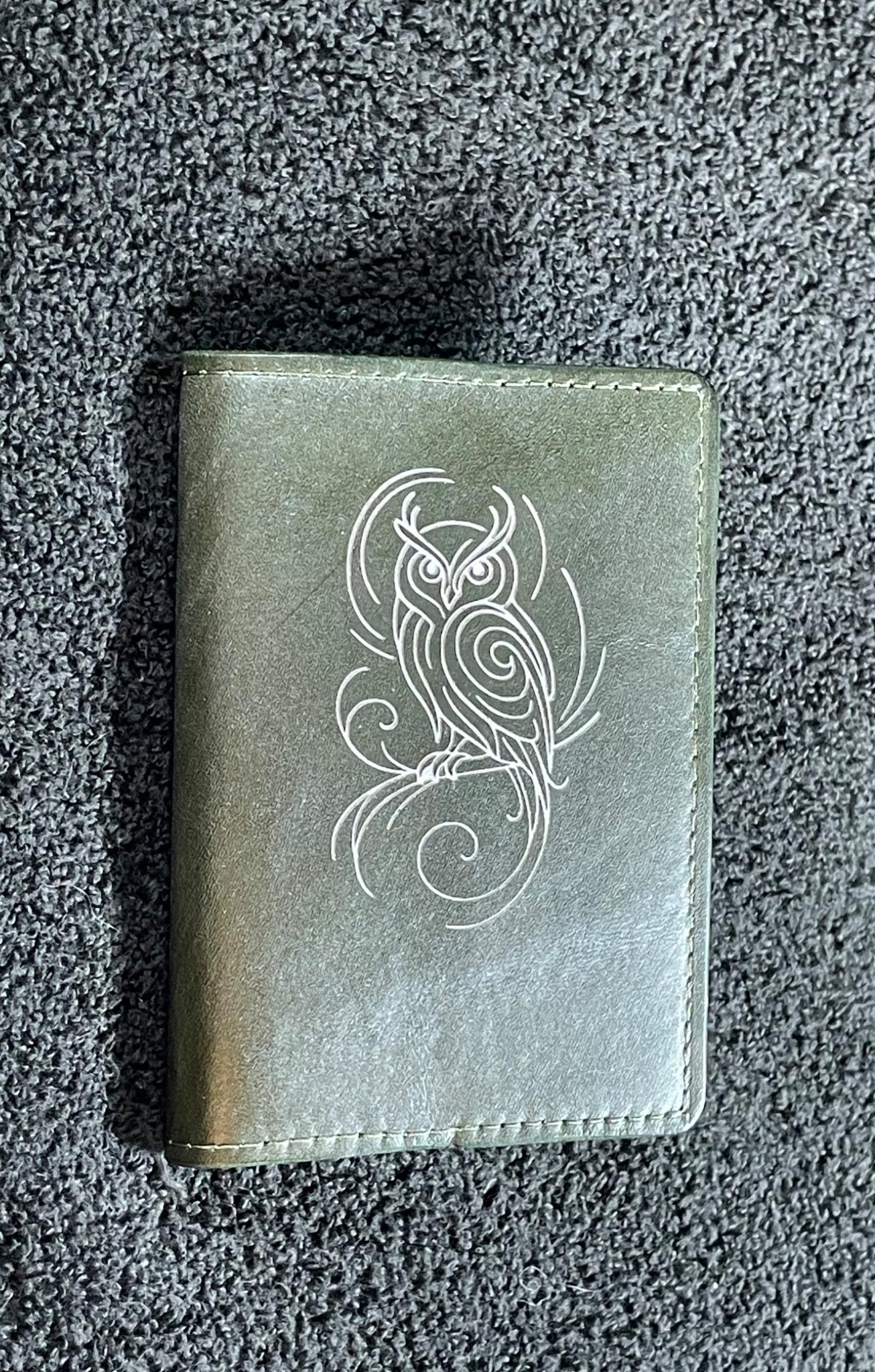 Small green leather notebook engraved with an ornamental flourish